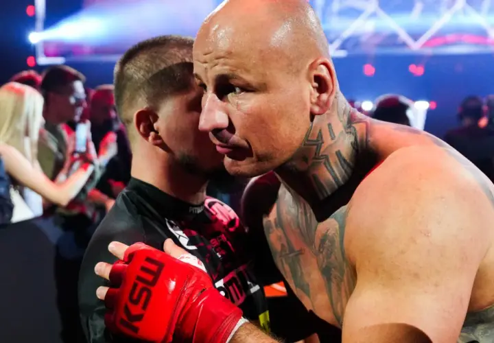 Artur Szpilka w czerwonej rękawicy KSW obejmuje przeciwnika.