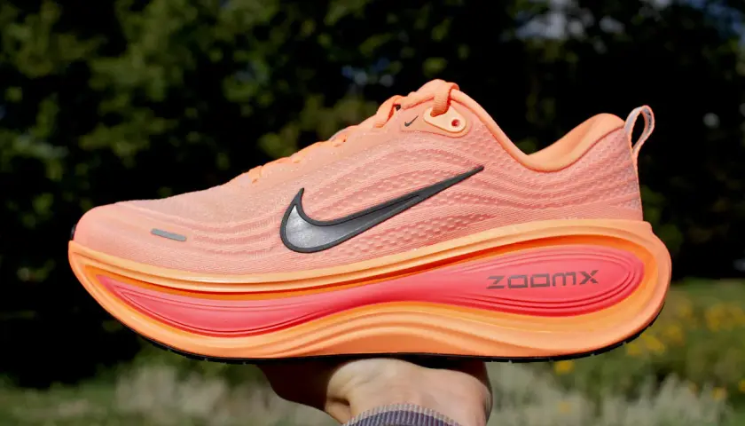 Pomarańczowy but do biegania Nike z czarnym logo i podeszwą ZoomX.