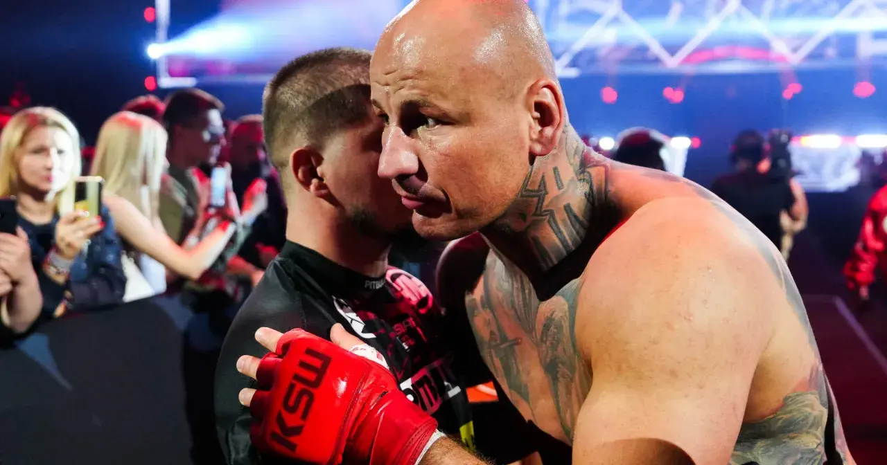 Artur Szpilka w czerwonej rękawicy KSW obejmuje przeciwnika.